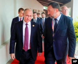 FILE - Russia's President Vladimir Putin, left, and Russian metals magnate Oleg Deripaska, right, walk to attend the APEC Business Advisory Council dialogue in Danang, Vietnam, Nov. 10, 2017.