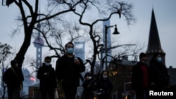 上海不断出现新冠病例后，行人戴着口罩行走在上海街头。（2022年2月14日）