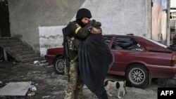 A Ukrainian soldier hugs his wife in the city of Irpin, north of Kyiv, March 10, 2022. 