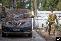 An Australian army soldier assists with the flood cleanup efforts in Gatton, Queensland, March 6, 2022, in this photo provided by Australian Department of Defense.
