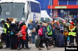People arrive a temporary accommodation and transport hub for refugees at a former shoping mall, after fleeing the Russian invasion of Ukraine, in Przemysl, Poland, March 6, 2022.