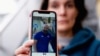 FILE - Oihana Goiriena, wife of journalist Pablo Gonzalez, shows a picture of her husband on her phone, after he was detained by Polish authorities on espionage charges, in Nabarniz, Spain, March 5, 2022.