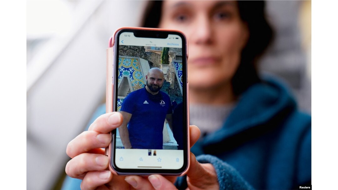 FILE - Oihana Goiriena, wife of journalist Pablo Gonzalez, shows a picture of her husband on her phone, after he was detained by Polish authorities on espionage charges, in Nabarniz, Spain, March 5, 2022.