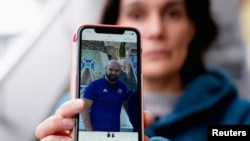 FILE - Oihana Goiriena, wife of journalist Pablo Gonzalez, shows a picture of her husband on her phone, after he was detained by Polish authorities on espionage charges, in Nabarniz, Spain, March 5, 2022.