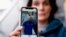 FILE - Oihana Goiriena, wife of journalist Pablo Gonzalez, shows a picture of her husband on her phone, after he was detained by Polish authorities on espionage charges, in Nabarniz, Spain, March 5, 2022.