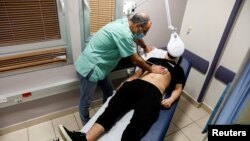 FILE - A patient suffering from Long COVID is examined in the post-coronavirus disease clinic of Ichilov Hospital in Tel Aviv, Israel, Feb. 21, 2022. 