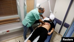 FILE - A patient suffering from Long COVID is examined in the post-coronavirus disease clinic of Ichilov Hospital in Tel Aviv, Israel, Feb. 21, 2022. 