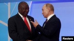 FILE - Russian President Vladimir Putin and South African President Cyril Ramaphosa speak during a Russia-Africa Summit in the Black Sea resort of Sochi, Russia. Taken Oct. 23, 2019.