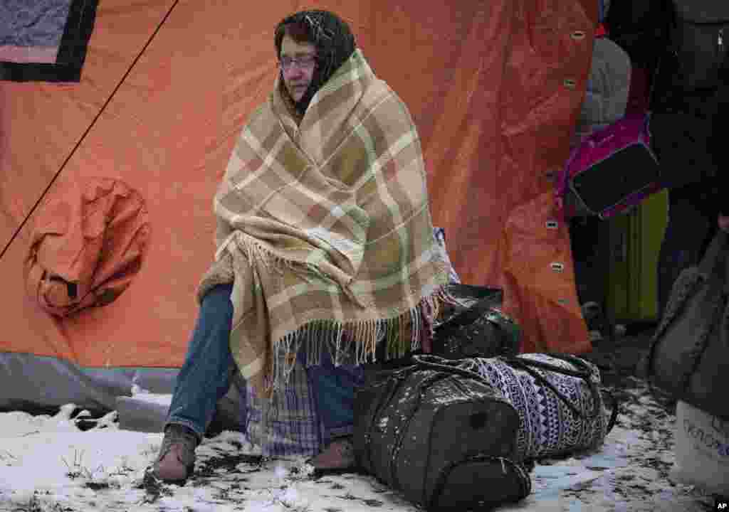 A woman fleeing from Ukraine is wrapped in a blanket to try to keep warm, at the border crossing in Medyka, Poland, March 9, 2022.