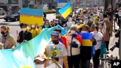 Para pengunjuk rasa memegang spanduk dan bendera saat unjuk rasa mengecam invasi Rusia ke Ukraina, di Tokyo, Sabtu, 5 Maret 2022. (Foto: AP)