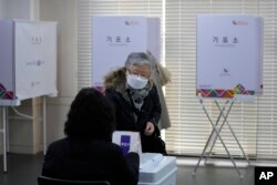 Yon elektè vote nan eleksyon prezidansyèl la nan yon biwo vot nan Seoul, kapital Kore di Sid, Mèkredi 9 Mas, 2022.