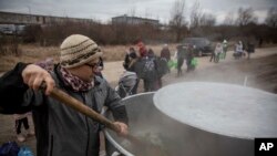 Czech volunteer Lukas Saranga cooks a soup in a giant pot for refugees fleeing Ukraine at the train station at border crossing of Medyka, Poland, March 8, 2022.