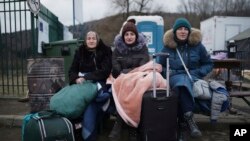 Three generations of women, from left, Svitlana, Lisa and Ludmilla, who fled from Odesa, Ukraine, sit at the border crossing in Kroscienko, Poland, March 8, 2022.