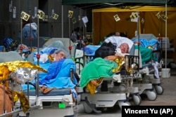 FILE - Patients lie on hospital beds waiting at a temporary holding area outside the Caritas Medical Centre in Hong Kong Wednesday, Feb. 16, 2022. (AP Photo Vincent Yu, File)