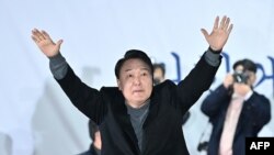 윤석열 한국 국민의힘 대통령 후보가 8일 서울에서 열린 유세에서 지지자들의 환호에 답하고 있다.
