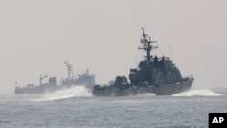FILE - South Korean Navy's patrol ships search for survivors from the sunken South Korean navy ship near South Korea's Baekryeong island, March 29, 2010. 