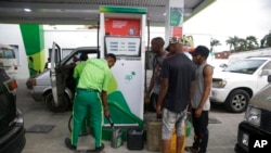 FILE - People queue at a petrol station in Lagos, Nigeria, Feb. 18, 2022. 