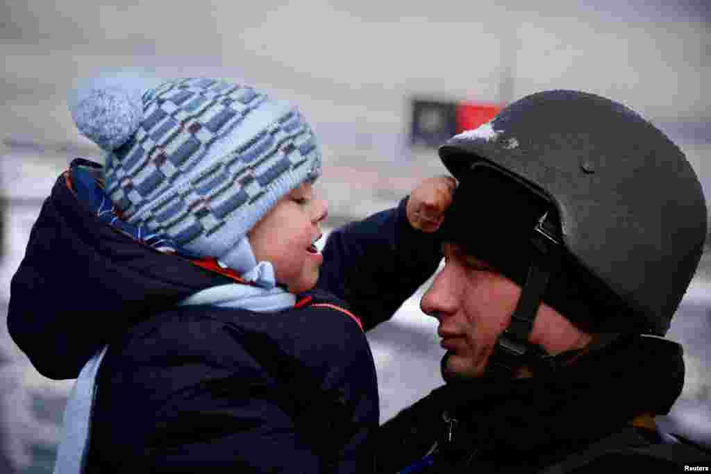 A police officer says goodbye to his son as his family flees from advancing Russian troops as Russia&#39;s attack on Ukraine continues in Irpin, March 8, 2022.