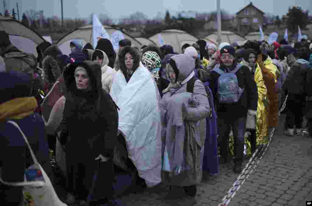 Los refugiados esperan transporte después de huir de Ucrania y llegar al cruce fronterizo en Medyka, Polonia.