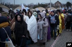 Pengungsi menunggu di kerumunan untuk mendapatkan transportasi setelah melarikan diri dari Ukraina dan tiba di perbatasan di Medyka, Polandia, Senin, 7 Maret 2022. (Foto: AP)