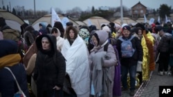 Refugiados esperan en una multitud para ser transportados después de huir de Ucrania y llegar al cruce fronterizo en Medyka, Polonia, el lunes 7 de marzo de 2022.