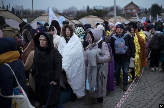 Pengungsi menunggu di kerumunan untuk mendapatkan transportasi setelah melarikan diri dari Ukraina dan tiba di perbatasan di Medyka, Polandia, Senin, 7 Maret 2022. (Foto: AP)