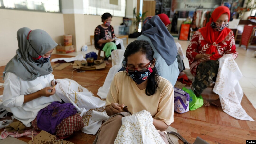 Para perempuan tampak mengenakan masker saat membatik di salah satu workshop di Jakarta, pada 1 Juli 2020. (Foto: Reuters/Willy Kurniawan)