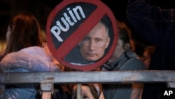 A girl holds a placard depicting Russian President Vladimir Putin at a protest against the Russia's invasion of Ukraine in Tel Aviv, Israel, March 5, 2022.