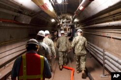 FILE - Navy and civilian water quality recovery experts walk through the tunnels of the Red Hill Bulk Fuel Storage Facility, near Pearl Harbor, Hawaii, in this Dec. 23, 2021, photo provided by the U.S. Navy.