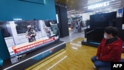 A resident watches a TV screen showing news about conflict between Russia and Ukraine at a shopping mall in Hangzhou, in China's eastern Zhejiang province on February 25, 2022. (Photo by AFP)