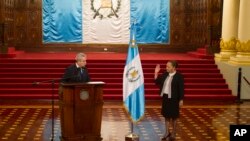 El secretario general de la Presidencia de Guatemala, Carlos Adolfo Martínez, izquierda, toma juramento a María Consuelo Porras como fiscal general dentro del Palacio Nacional en Ciudad de Guatemala, el 16 de mayo de 2018. 