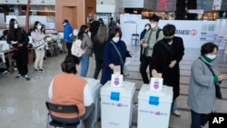 People cast their early votes for the March 9 presidential election at a local polling station in Seoul, South Korea, Saturday, March 5, 2022. (AP Photo/Ahn Young-joon)