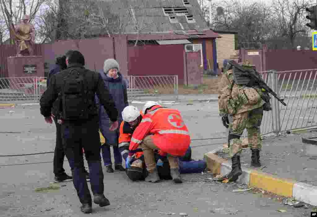 Paramedics administer first aid to an elderly man who fainted after crossing the Irpin river to flee the town, Ukraine, March 7, 2022. 