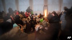 Refugees, mostly women with children, rest inside a tent after arriving at the border crossing, in Medyka, Poland, March 6, 2022.