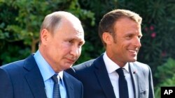 Presiden Prancis Emmanuel Macron (kanan) menyambut Presiden Rusia Vladimir Putin di in Bormes-les-Mimosas, di wilayah selatan Prancis, pada 19 Agustus 2019. (Foto: Pool via AP/Gerard Julien)