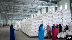 FILE - Workers clean the floor as sacks of food earmarked for the Tigray and Afar regions sits in piles in a warehouse of the World Food Programme (WFP) in Semera, the regional capital for the Afar region, in Ethiopia, Feb. 21, 2022. 