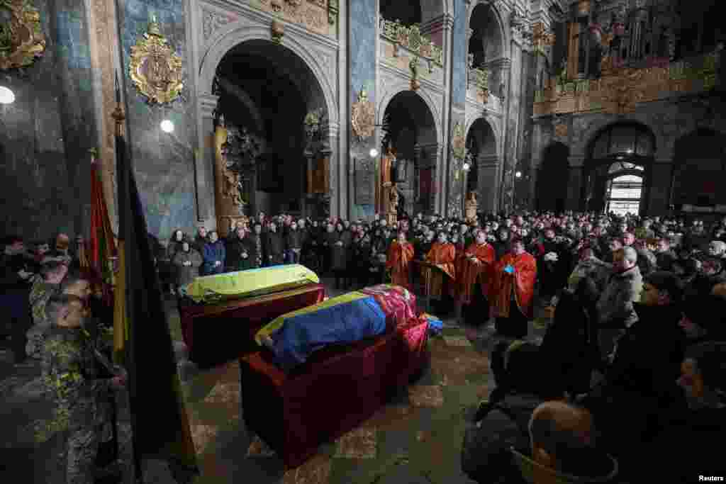 People attend a memorial service to pay their respects to Viktor Dudar and Ivan Koverznev, Ukrainian servicemen killed on March 2, during Russia&#39;s invasion of Ukraine, in a Jesuit Church (Church of the Most Holy Apostles Peter and Paul) in central Lviv.
