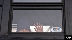 Un niño migrante permanece en un autobús mientras las autoridades desmantelan un campamento improvisado en las afueras del puerto de cruce de El Chaparral en Tijuana, estado de Baja California, México, cerca de la frontera con los EE. UU., el 6 de febrero de 2022.