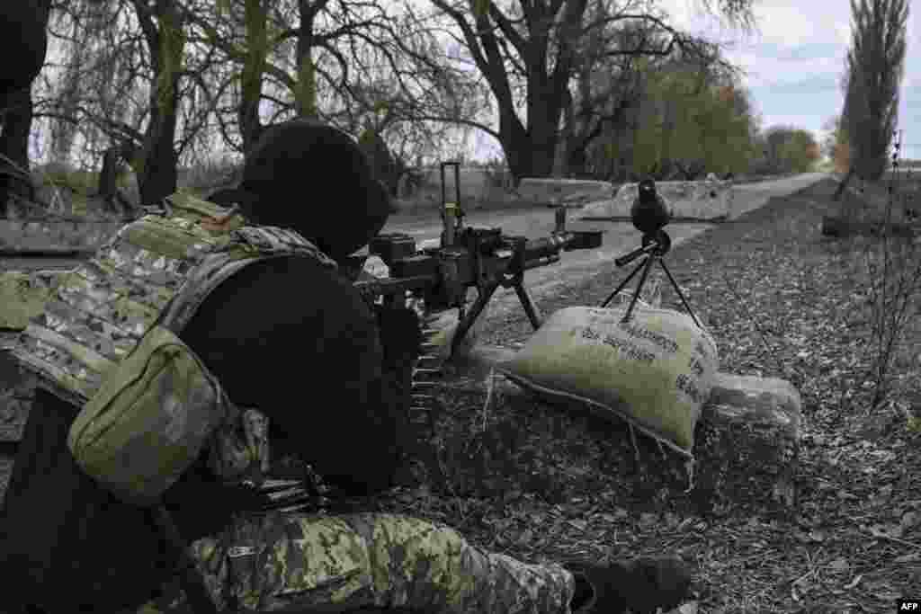 A Ukrainian serviceman aims toward Russian positions outside the city of Brovary, east of Kyiv, March 9, 2022.