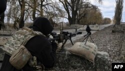 A Ukrainian serviceman aims toward Russian positions outside the city of Brovary, east of Kyiv, March 9, 2022.