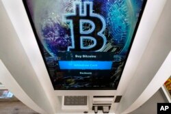 FILE - The Bitcoin logo appears on the display screen of a cryptocurrency ATM in Salem, New Hampshire, Feb. 9, 2021.