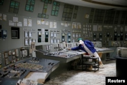 Seorang karyawan terlihat di pusat kendali salah satu reaktor yang berhenti di Pembangkit Listrik Tenaga Nuklir Chernobyl di Chernobyl, Ukraina, 25 Maret 2021. (Foto: Reuters)