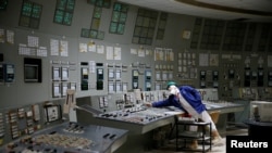 FILE - An employee is seen in a control center of one of the stopped reactors at the Chernobyl Nuclear Power Plant in Chernobyl, Ukraine, March 25, 2021. 