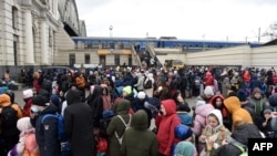 People wait for a train to Poland at the railway station of the western Ukrainian city of Lviv, March 6, 2022, 11 days after Russia launched a military invasion on Ukraine. 