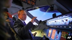 Russian President Vladimir Putin sits in the cockpit of an airplane simulator as he visits Aeroflot Aviation School outside Moscow, Russia, March 5, 2022. (Sputnik, Kremlin Pool Photo via AP)