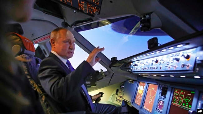 Russian President Vladimir Putin sits in the cockpit of an airplane simulator as he visits Aeroflot Aviation School outside Moscow, Russia, March 5, 2022. (Sputnik, Kremlin Pool Photo via AP)