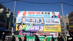 Placards featuring ruling and opposition presidential candidates hang over a street in Seoul, South Korea on Feb. 17, 2022. Just days before March 9 election, Lee Jae-myung from the liberal governing Democratic Party and Yoon Suk Yeol from the main conservative opposition People Power Party are locked in an extremely tight race. (AP Photo/Ahn Young-joon)