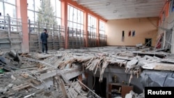 지난 5일 우크라이나 제2 도시 하르키우(러시아명 하리코프)에 있는 스포츠센터 관계자가 폭격으로 파괴된 시설을 살피고 있다.
