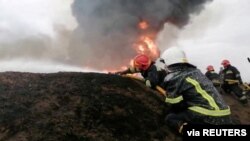 Para petugas tanggap darurat tampak berusaha memadamkan api setelah sebuah peluru kendali menghancurkan gedung di Bandara Internasional Havryshivka Vinnytsia, Ukraina, pada 6 Maret 2022. (Foto: State Emergency Service of Ukraine/Handout via Reuters)
