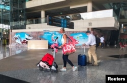 Wisatawan asing yang membawa barang bawaannya berjalan kaki saat tiba di Bandara Internasional I Gusti Ngurah Rai. (Foto: REUTERS)